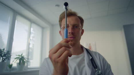 Neurologist-examining-patient-visual-reflex-using-neurological-hammer-pov-video