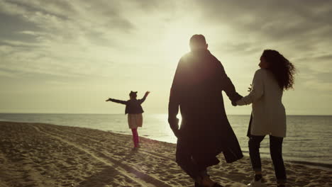 Family-look-sunset-beach-on-lovely-nature-walk.-People-group-enjoy-ocean-coast.