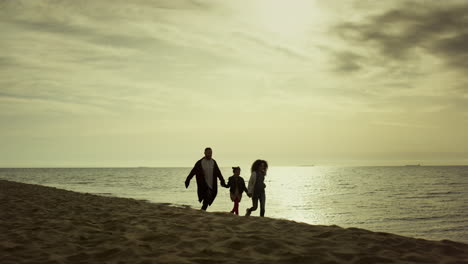 Junge-Familie,-Die-Am-Meeresufer-Läuft.-Menschen,-Die-Gemeinsam-Eine-Schöne-Zeit-Am-Strand-Haben.