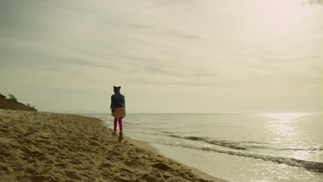 Girl-running-sand-sea-at-sunset.-Little-child-explore-empty-beach-on-sunny-day.