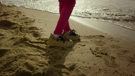 Kleine-Mädchenbeine-Gehen-Auf-Meeresstrandsand.-Kinderfüße-Verschwinden,-Krachende-Wellen