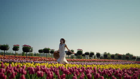 Young-woman-running-in-tulip-field.-Girl-moving-fast-in-flower-garden.