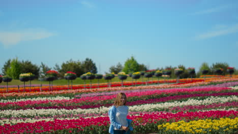Happy-girl-running-on-floral-background-outdoors.-Young-woman-in-tulip-field.