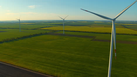 Windgeneratoren-Zwischen-Grünen-Feldern,-Die-Umweltfreundlichen,-Erneuerbaren-Strom-Produzieren.