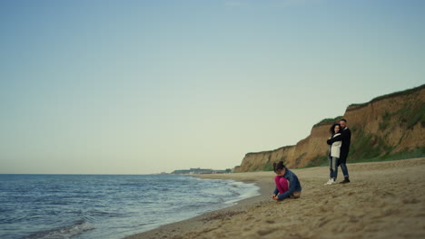 Family-resting-sea-beach-at-calm-crashing-waves.-People-enjoy-holiday-at-ocean.
