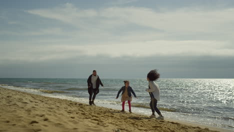 Gente-Saltando-Playa-De-Mar.-La-Familia-Juguetona-Disfruta-De-Unas-Felices-Vacaciones-En-La-Naturaleza-Junto-Al-Mar.