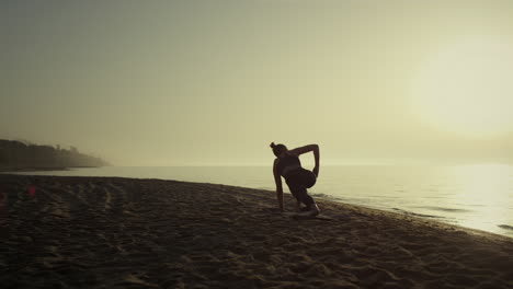 Yoga-Frau-Macht-Plank-Pose-Und-Hebt-Die-Hand.-Mädchen,-Das-Sich-Am-Sandstrand-Ausdehnt
