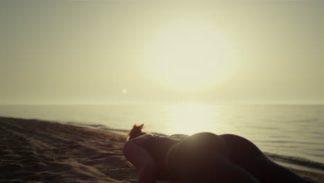 Sporty-girl-training-yoga-on-sandy-beach.-Woman-making-plank-pose-at-sunset