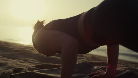 Athletic-girl-training-flexibility-making-yoga-exercises-on-seashore-close-up.