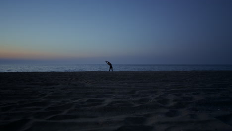 Silhouette-Einer-Frau,-Die-Am-Späten-Abend-Yoga-Am-Strand-Macht.-Mädchen,-Das-Sich-Am-Meeresufer-Ausdehnt.