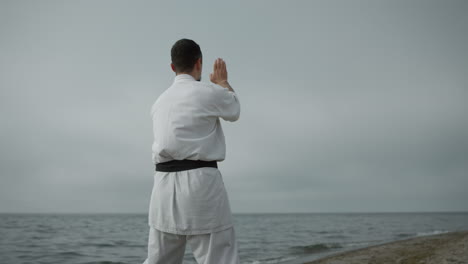 Unknown-karate-fighter-practicing-attacks-in-overcast-weather-by-day.