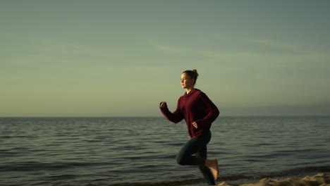 Girl-runner-training-sandy-beach-evening-time.-Sporty-woman-running-near-ocean.
