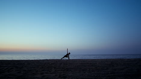 Silhouette-yoga-woman-training-warrior-asana-in-front-beautiful-sunset-sky.