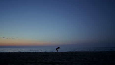 Silhouette-Eines-Sportlermädchens,-Das-In-Der-Abenddämmerung-An-Der-Küste-Trainiert.-Frau-Praktiziert-Yoga.