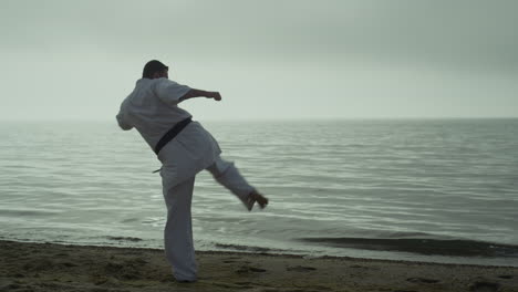 Bearded-sportsman-practicing-attack-on-sunset-outdoor.-Karate-man-learning-kicks