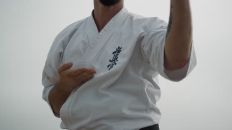 Sporty-man-exercising-karate-on-beach-close-up.-Fighter-training-matrial-art.