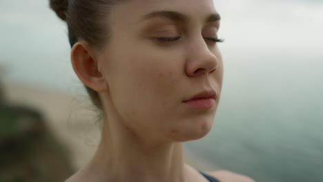 Closed-eyed-girl-meditating-on-beach-close-up.-Woman-breathing-practicing-yoga.