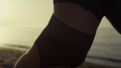 Slim-girl-body-training-svanasana-on-beach-close-up.-Woman-stretching-on-nature.