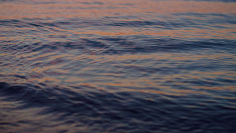 Nahaufnahme-Der-Meerwasseroberfläche,-Die-Den-Violetten-Himmel-Bei-Sonnenuntergang-Am-Abend-Reflektiert.