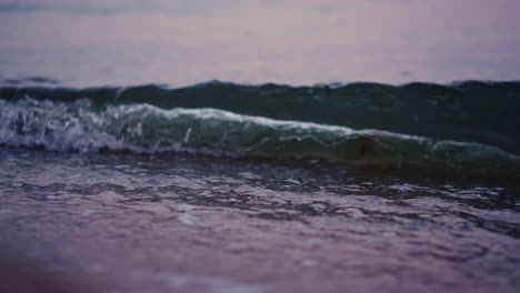 Ocean-waves-splashing-sandy-beach-in-slow-motion.-Sea-water-waving-at-sand-beach