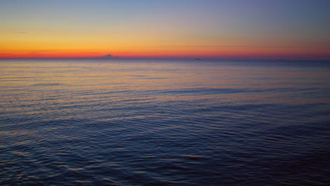 Sonnenuntergang-Am-Meer,-Der-Sich-In-Der-Abenddämmerung-An-Der-Wasseroberfläche-Spiegelt.-Ruhige-Blaue-Meereswellen