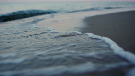 Evening-seashore-close-up.-Closeup-calm-ocean-water-waves-splashing-sandy-beach