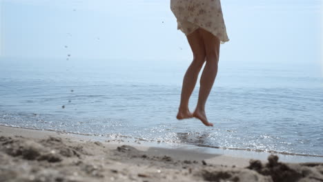 Bare-woman-feet-jumping-in-ocean-water-close-up.-Girl-have-fun-bouncing-on-waves