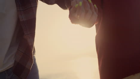 Couple-holding-hands-at-sea-beach.-Loving-girl-and-guy-walking-along-ocean-shore