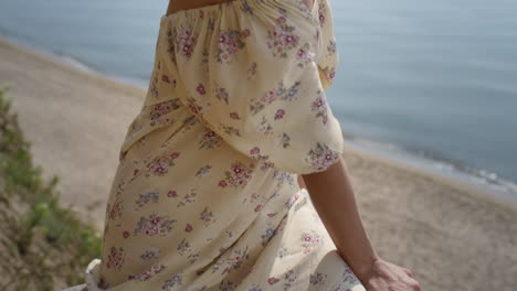 Adorable-woman-relax-on-beach-wearing-flowery-dress-closeup.-Portrait-curly-girl