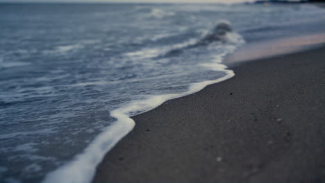 Water-tide-breaking-beach-on-sunset-nature-shore.-Sea-wave-crashing-sandy-coast.