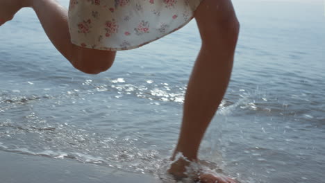 Schlankes-Mädchen,-Das-An-Einem-Sommertag-Meerwasser-Mit-Hut-Laufen-Lässt.-Nahaufnahme-Der-Beine-Einer-Frau-Beim-Gehen