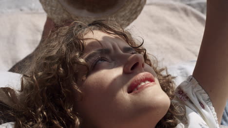 Beautiful-woman-hiding-face-from-sunlight-by-hand-close-up.-Portrait-curly-girl.