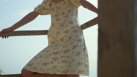 Relaxed-woman-leaning-railings-on-seashore.-Girl-posing-on-beach-wearing-dress.