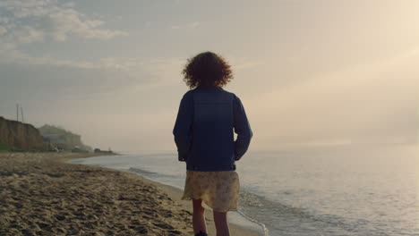 Casual-woman-walking-on-sandy-beach.-Stylish-girl-exploring-ocean-coast