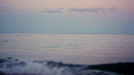 Calm-ocean-surface-horizon-at-pink-sky-in-cold-morning-dawn.-Sea-water-waves