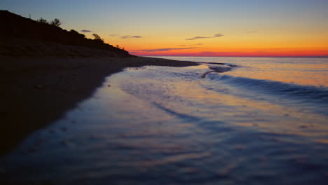 Felsige-Küste-Bei-Orangefarbenem-Sonnenuntergang.-Ruhige-Meereslandschaft-Am-Dunklen-Sandstrand