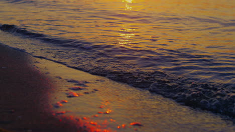 Warmes-Meerwasser-Plätschert-Am-Dunklen-Sandstrand-Bei-Goldenem-Sonnenuntergang.-Ozean-Wellen