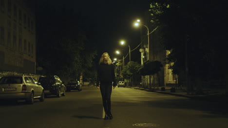 Mujer-Caminando-Sola-De-Noche-Con-Ropa-Informal-En-La-Carretera-De-La-Ciudad.