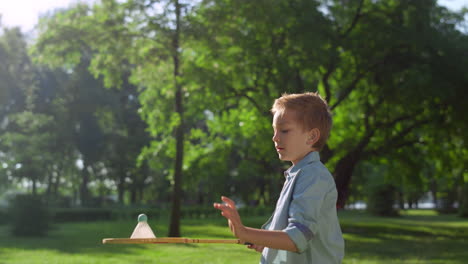 Focused-boy-failed-to-hit-shuttlecock-on-sunny-day.-Family-picnic-time