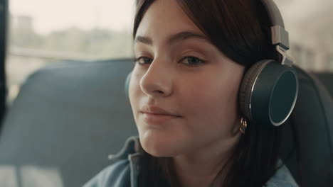 Dreamy-girl-face-listening-music-with-headphones-closeup.-Schoolgirl-smiling.