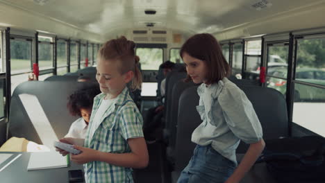 Preteen-classmates-playing-talking-in-school-bus.-Teen-kids-waiting-riding-home.