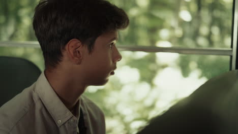 Indian-boy-sitting-school-bus-alone-close-up.-Teen-schoolboy-looking-window.