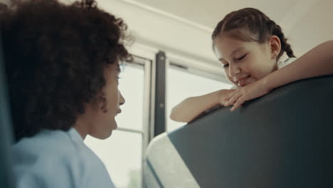 Afroamerikanisches-Mädchen,-Das-Mit-Klassenkamerad-Im-Bus-Spricht.-Teenager-Freunde-Nutzen-Gadget.