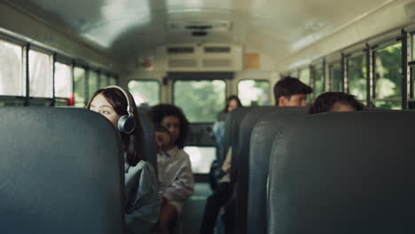 Verschiedene-Schüler-Sitzen-Im-Schulbus-Zusammen.-Gemischtrassige-Teenager,-Die-Nach-Hause-Gehen.