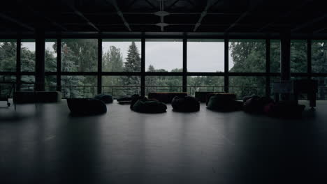Modern-empty-hall-interior-with-bag-chairs-sofa-at-panorama-window-background.