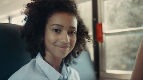 African-American-schoolgirl-looking-camera-in-school-bus-close-up.-Girl-posing.