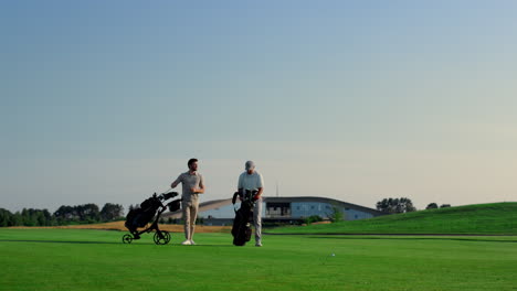 Golfer-Diskutieren-Draußen-über-Kursspielwettbewerbe.-Zwei-Männer-Wählen-Putter-Auf-Dem-Feld-Aus