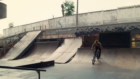 Millennial-man-performing-extreme-tricks-on-bmx-bike-at-urban-space.