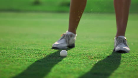 Sporty-woman-legs-golfing-at-green-course.-Golfer-train-hitting-ball-on-fairway.