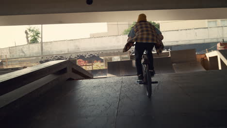 Young-biker-performing-rail-stunt-at-urban-skate-park.-Rider-racing-on-bmx.